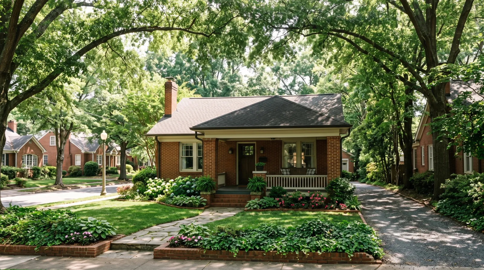 A brick bungalow under a canopy of mature willow oaks on an established Charlotte street